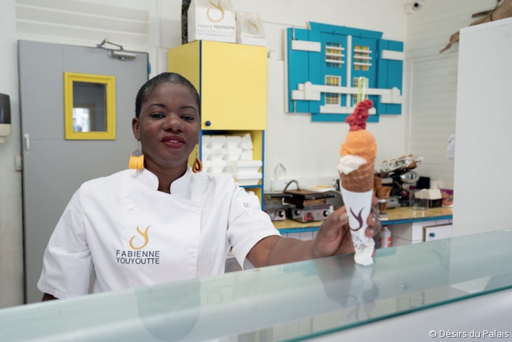 L'artisan guadeloupéenne Fabienne Youyoutte tenant une glace dans sa boutique