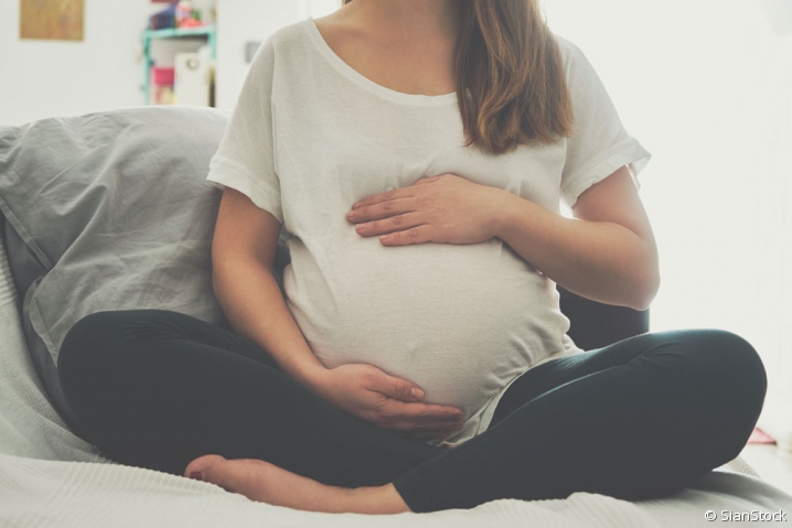 Femme enceinte Femme enceinte assise en tailleur et touchant son ventre