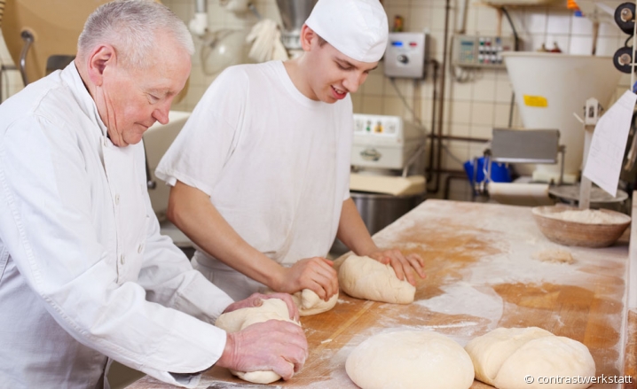 Artisan boulanger pétrissant des pâtons aux côtés de son apprenti Artisan boulanger pétrissant des pâtons aux côtés de son apprenti